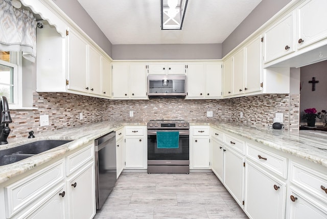 466 Emanuel Rd, Goodrich, TX 77335 - kitchen featuring appliances with stainless steel finishes, a sink, white cabinetry, and backsplash