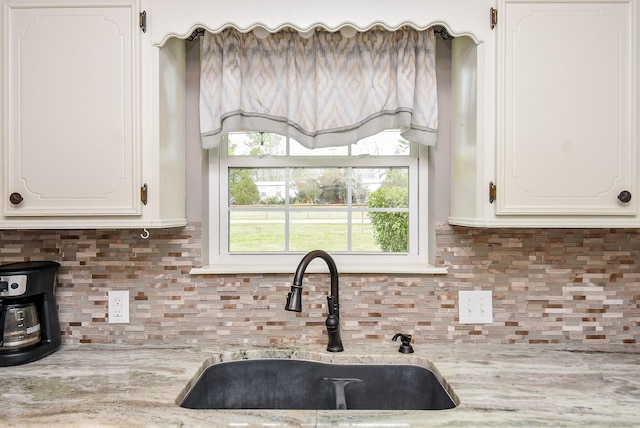 466 Emanuel Rd, Goodrich, TX 77335 - kitchen featuring a sink, white cabinets, decorative backsplash, and light stone countertops