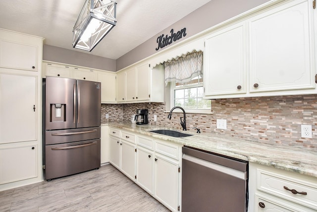 466 Emanuel Rd, Goodrich, TX 77335 - kitchen featuring stainless steel appliances, a sink, decorative backsplash, and white cabinetry