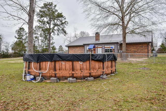 466 Emanuel Rd, Goodrich, TX 77335 - rear view of property with brick siding, a chimney, and metal roof