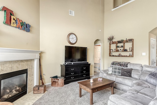 3626 Avalon Spring Ln, Spring, TX 77386 - living area with arched walkways, a towering ceiling, a tile fireplace, carpet, and baseboards