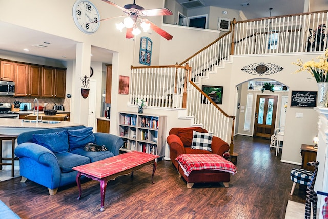 13926 Wessex Park Dr, Cypress, TX 77429 - living area with a towering ceiling, a ceiling fan, stairs, wood finished floors, and arched walkways