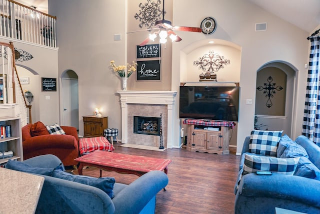 13926 Wessex Park Dr, Cypress, TX 77429 - living room featuring arched walkways, ceiling fan, high vaulted ceiling, a tiled fireplace, and wood finished floors