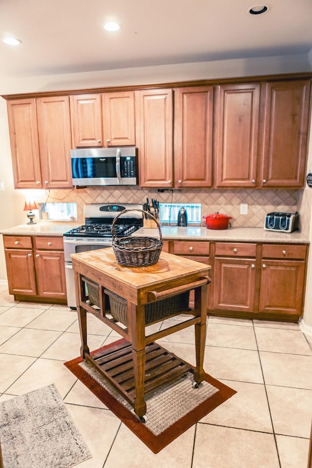 13926 Wessex Park Dr, Cypress, TX 77429 - kitchen with appliances with stainless steel finishes, tasteful backsplash, light tile patterned flooring, light countertops, and recessed lighting