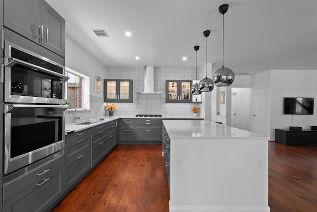 21519 Canyon Terrace Ln, Katy, TX 77450 - kitchen with wall chimney range hood, a sink, a kitchen island, dark wood finished floors, and recessed lighting