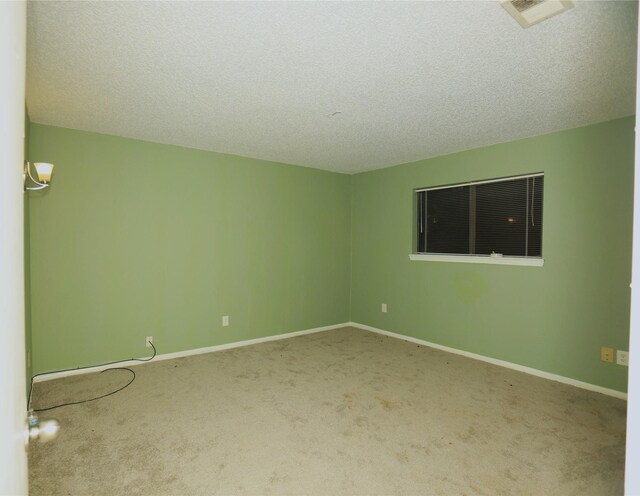 2236 River Oaks Dr, West Columbia, TX 77486 - empty room featuring carpet floors, a textured ceiling, and baseboards