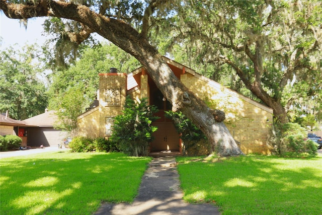 2236 River Oaks Dr, West Columbia, TX 77486 - mid-century inspired home featuring a chimney, brick siding, and a front yard