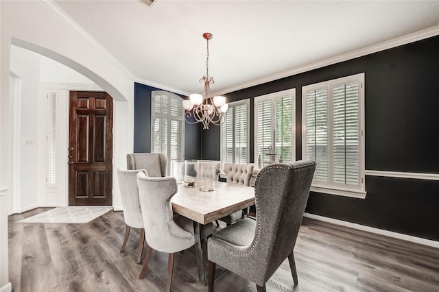 21622 Sabine Pass Ct, Katy, TX 77450 - dining room featuring a chandelier, arched walkways, wood finished floors, and ornamental molding