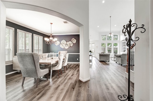 21622 Sabine Pass Ct, Katy, TX 77450 - dining area with wood finished floors, arched walkways, a chandelier, crown molding, and recessed lighting