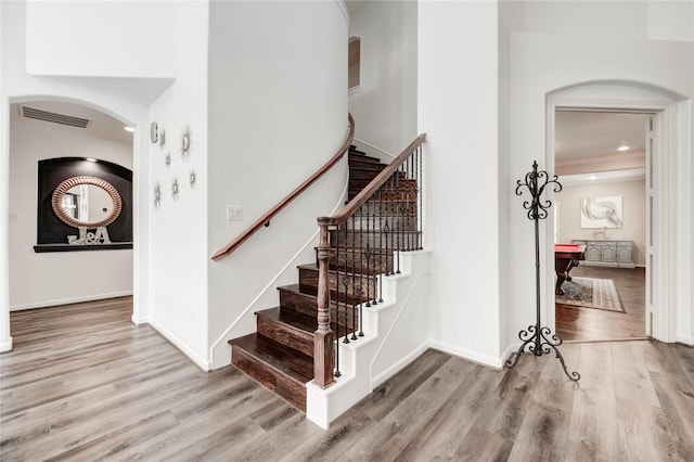 21622 Sabine Pass Ct, Katy, TX 77450 - staircase featuring arched walkways, wood finished floors, and recessed lighting