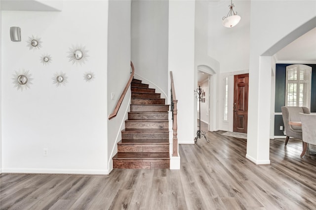 21622 Sabine Pass Ct, Katy, TX 77450 - entryway featuring light wood-style flooring, stairs, arched walkways, and a towering ceiling