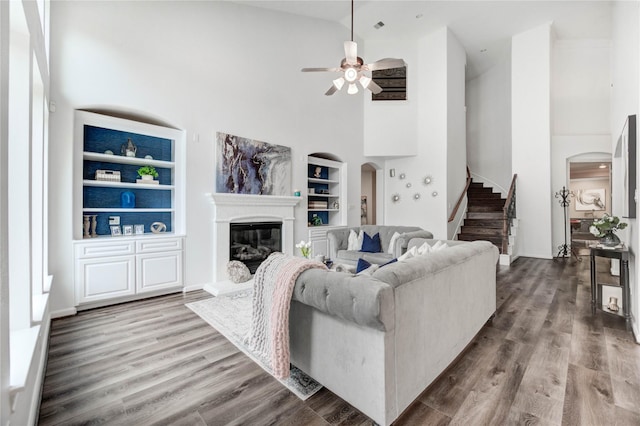 21622 Sabine Pass Ct, Katy, TX 77450 - living area featuring high vaulted ceiling, built in features, arched walkways, ceiling fan, and a glass covered fireplace