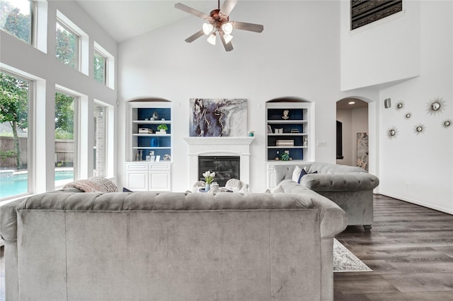 21622 Sabine Pass Ct, Katy, TX 77450 - living area with high vaulted ceiling, a ceiling fan, built in shelves, dark wood finished floors, and a glass covered fireplace