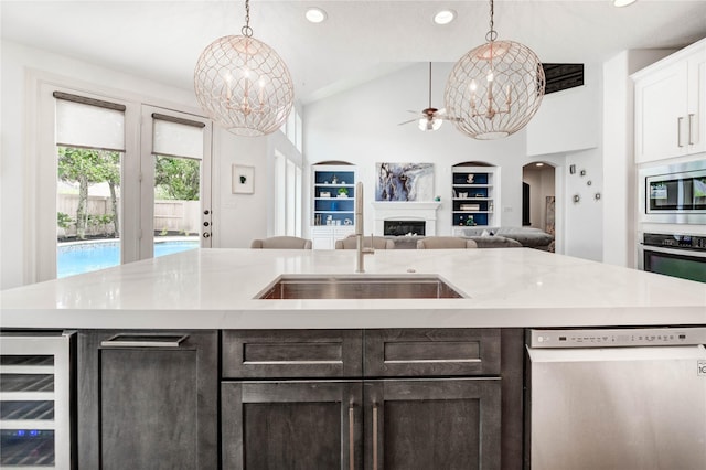 21622 Sabine Pass Ct, Katy, TX 77450 - kitchen featuring appliances with stainless steel finishes, beverage cooler, built in shelves, light countertops, and open floor plan