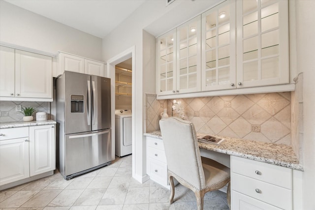 701 Bering Dr Unit 1702, Houston, TX 77057 - kitchen with stainless steel fridge with ice dispenser, washer / clothes dryer, glass insert cabinets, light stone countertops, and tasteful backsplash