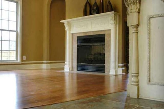 301 Live Oak St, Gonzales, TX 78629 - detailed view of a glass covered fireplace, arched walkways, wood finished floors, and baseboards