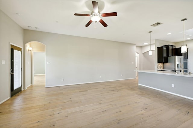 10315 Silver Shield Way, Tomball, TX 77375 - unfurnished living room featuring arched walkways, ceiling fan, light wood-style floors, baseboards, and recessed lighting