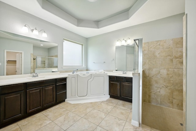 10315 Silver Shield Way, Tomball, TX 77375 - bathroom with a shower stall, a tray ceiling, two vanities, tile patterned flooring, and a bath