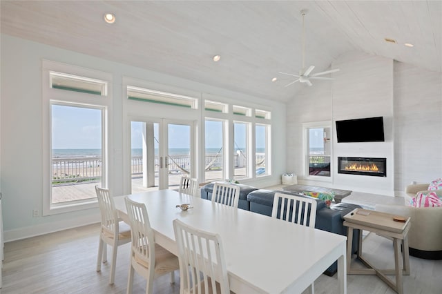 852 W Lazy Ln, Crystal Beach, TX 77650 - dining room featuring ceiling fan, light wood-style floors, a glass covered fireplace, recessed lighting, and high vaulted ceiling