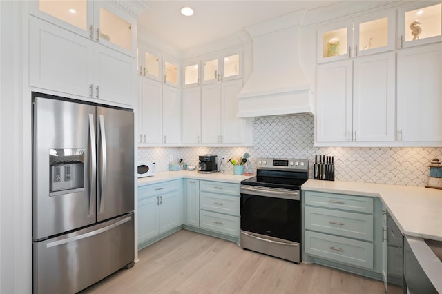 852 W Lazy Ln, Crystal Beach, TX 77650 - kitchen with stainless steel appliances, light countertops, custom exhaust hood, white cabinets, and recessed lighting