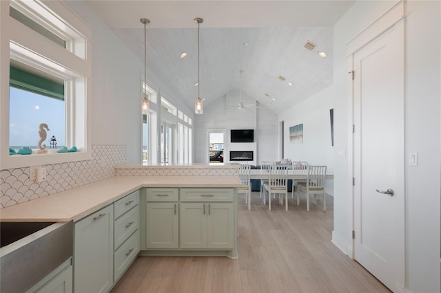 852 W Lazy Ln, Crystal Beach, TX 77650 - kitchen featuring healthy amount of natural light, light wood finished floors, backsplash, light countertops, and high vaulted ceiling