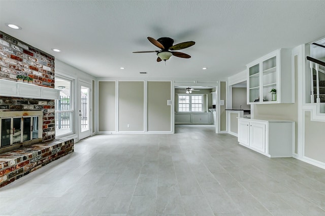 1406 Rustic Knolls Dr, Katy, TX 77450 - unfurnished living room with ceiling fan and a fireplace