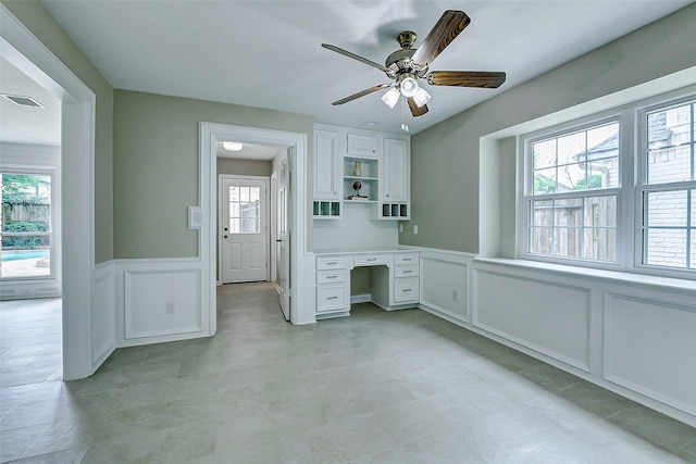 1406 Rustic Knolls Dr, Katy, TX 77450 - unfurnished office with a decorative wall, healthy amount of natural light, light tile patterned floors, built in study area, and a wainscoted wall