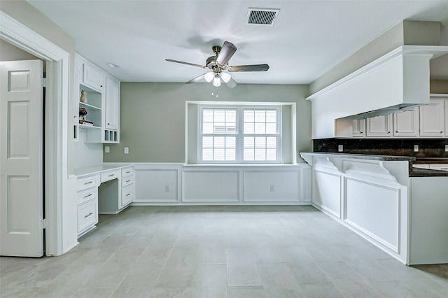 1406 Rustic Knolls Dr, Katy, TX 77450 - kitchen with a ceiling fan, white cabinetry, dark countertops, wainscoting, and open shelves