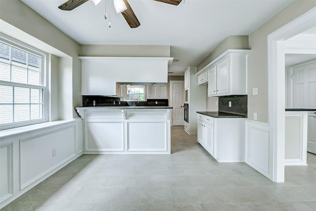 1406 Rustic Knolls Dr, Katy, TX 77450 - kitchen featuring a sink, oven, a ceiling fan, decorative backsplash, and dark countertops