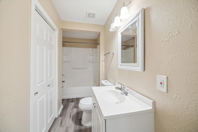 4446 Castor St, Houston, TX 77022 - full bath featuring vanity, a textured wall, toilet, wood finished floors, and bathing tub / shower combination