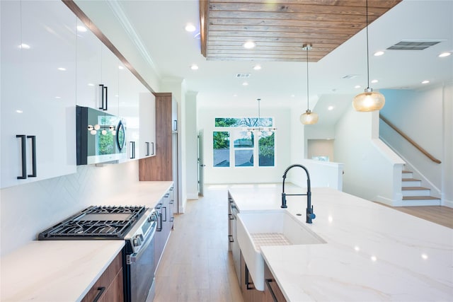 2117A Sauer, Houston, TX 77004 - kitchen featuring modern cabinets, stainless steel appliances, light wood-style floors, a sink, and white cabinetry