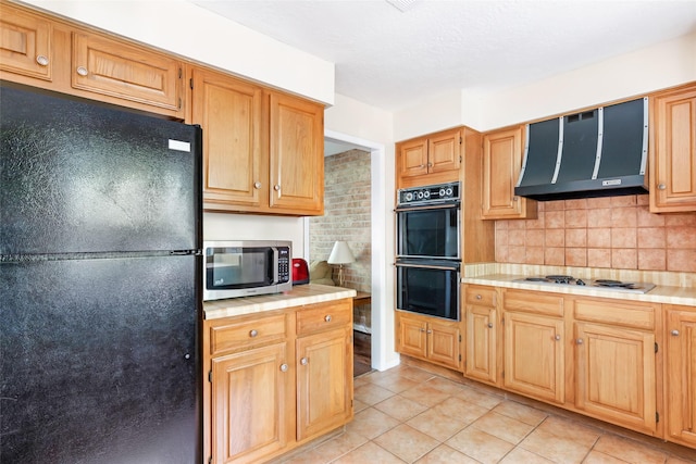 3734 Glade Forest Dr, Kingwood, TX 77339 - kitchen with black appliances, ventilation hood, tile counters, light tile patterned floors, and decorative backsplash