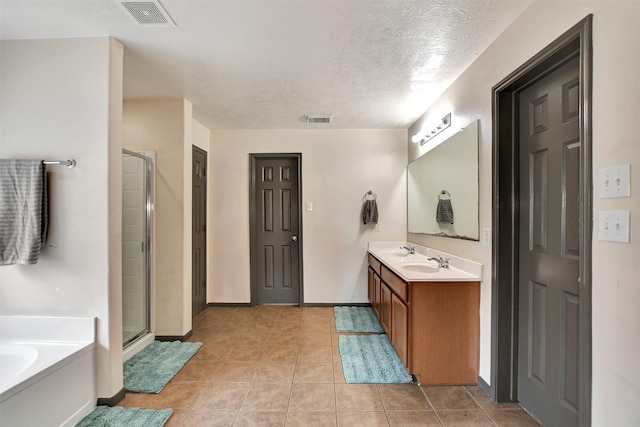6706 Lindale Manor Ct, Spring, TX 77379 - bathroom with double vanity, a stall shower, a garden tub, tile patterned flooring, and a textured ceiling
