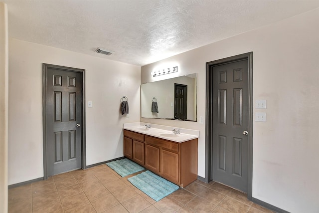 6706 Lindale Manor Ct, Spring, TX 77379 - bathroom featuring double vanity, a textured ceiling, baseboards, and tile patterned flooring