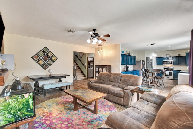 6706 Lindale Manor Ct, Spring, TX 77379 - living room with a ceiling fan, light wood-style floors, a chandelier, and stairs