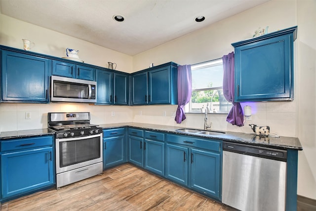 6706 Lindale Manor Ct, Spring, TX 77379 - kitchen featuring appliances with stainless steel finishes, blue cabinetry, tasteful backsplash, light wood-style flooring, and recessed lighting