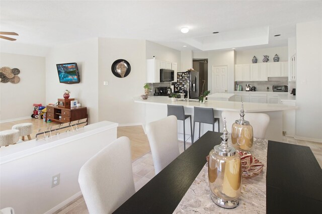 3334 Barkers Forest Ln, Houston, TX 77084 - dining area featuring a tray ceiling, ceiling fan, and baseboards