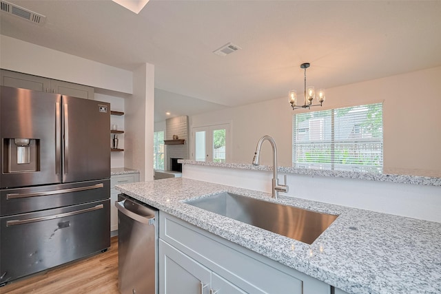 19803 Packwood Dr, Katy, TX 77449 - kitchen featuring stainless steel appliances, light stone countertops, light wood-style flooring, and plenty of natural light