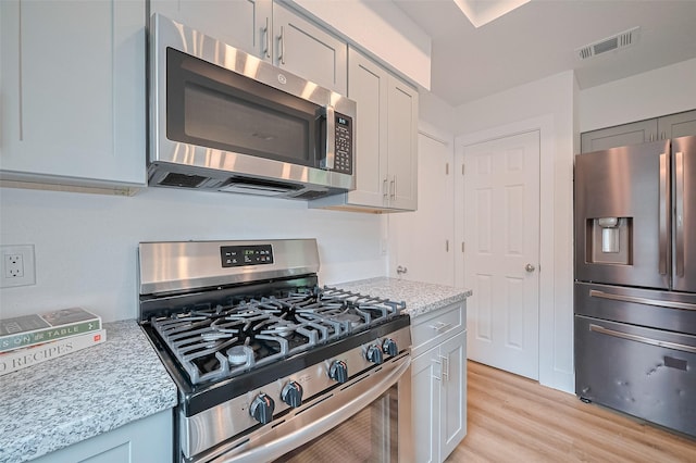 19803 Packwood Dr, Katy, TX 77449 - kitchen with appliances with stainless steel finishes, light wood finished floors, and light stone counters