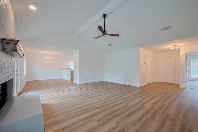 19803 Packwood Dr, Katy, TX 77449 - unfurnished living room with a ceiling fan, a brick fireplace, light wood-style flooring, and a chandelier