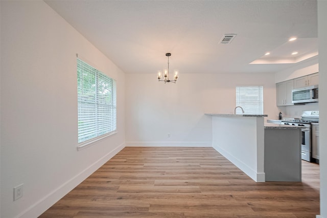 19803 Packwood Dr, Katy, TX 77449 - kitchen with stainless steel microwave, range with gas stovetop, healthy amount of natural light, a chandelier, and recessed lighting