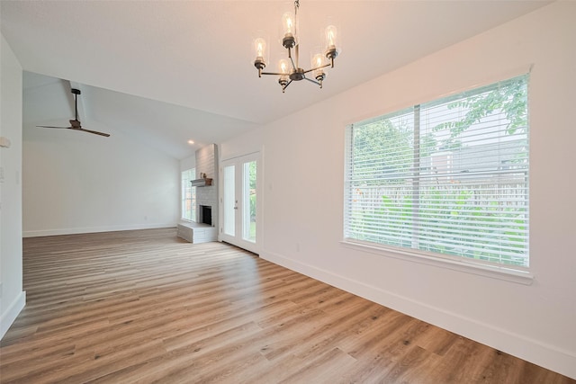19803 Packwood Dr, Katy, TX 77449 - unfurnished living room featuring healthy amount of natural light, a chandelier, a brick fireplace, lofted ceiling, and light wood-style flooring