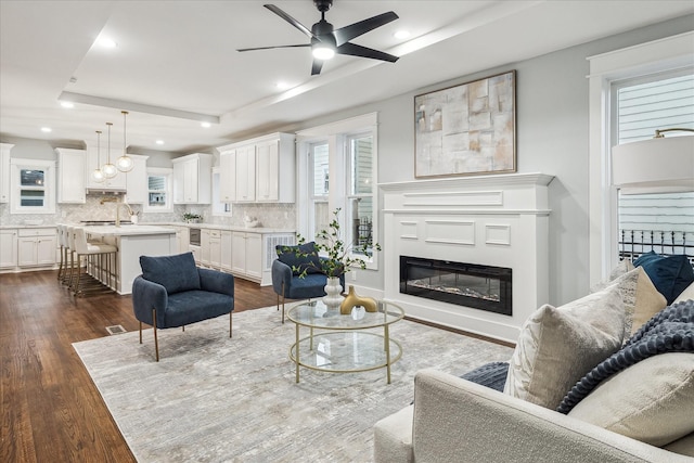 1819 Oxford St, Houston, TX 77008 - living room with ceiling fan, dark wood finished floors, a glass covered fireplace, recessed lighting, and a raised ceiling