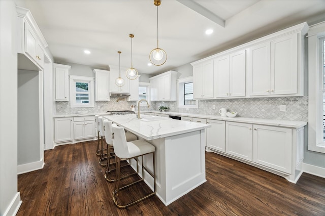 1819 Oxford St, Houston, TX 77008 - kitchen with decorative backsplash, an island with sink, white cabinetry, dark wood-type flooring, and recessed lighting