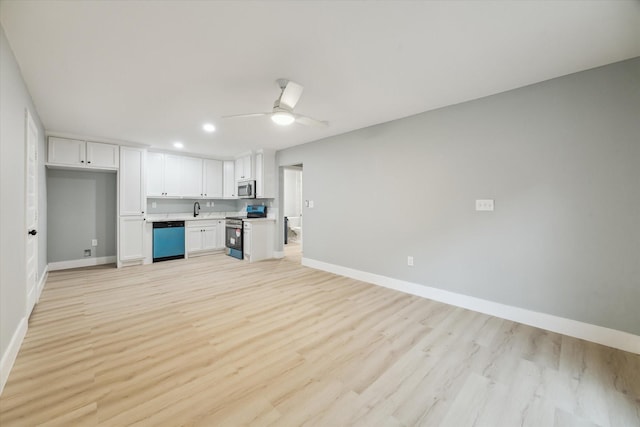 1819 Oxford St, Houston, TX 77008 - kitchen with stainless steel appliances, open floor plan, white cabinets, a ceiling fan, and light wood finished floors
