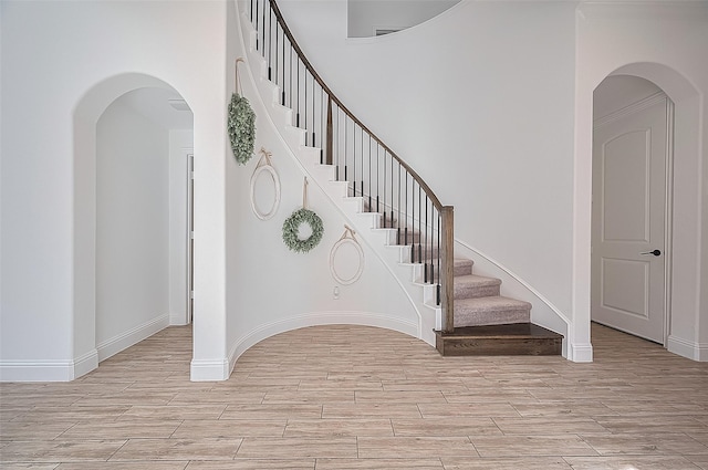 18003 Winding Willow Oak Way, Cypress, TX 77433 - stairway featuring wood finished floors and arched walkways