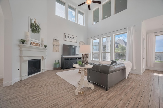 18003 Winding Willow Oak Way, Cypress, TX 77433 - living area with ceiling fan, wood finished floors, a towering ceiling, and a fireplace