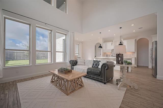 18003 Winding Willow Oak Way, Cypress, TX 77433 - living area with arched walkways and light wood-style flooring