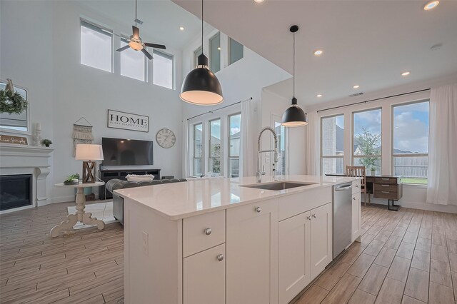 18003 Winding Willow Oak Way, Cypress, TX 77433 - kitchen featuring stainless steel dishwasher, open floor plan, healthy amount of natural light, light wood finished floors, and recessed lighting