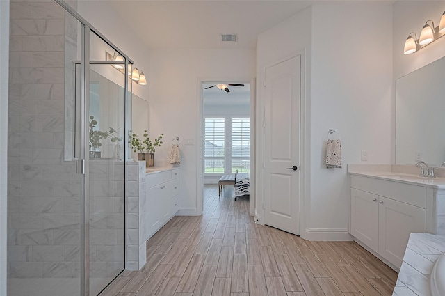 18003 Winding Willow Oak Way, Cypress, TX 77433 - full bath featuring two vanities, a ceiling fan, a shower stall, and wood tiled floors